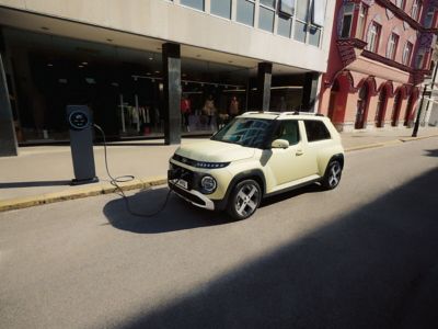Hyundai INSTER parked on the roadside charging.
