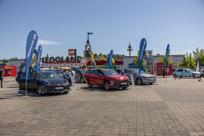 Das Hyundai Maskottchen “Fredi” auf dem Parkplatz vor dem Legoland mit einem IONIQ 5, Hyundai KONA N Line und IONIQ 6.