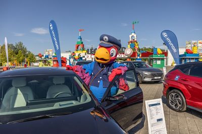 Der Hyundai IONIQ 5 mit dem Hyundai Maskottchen „Fredi“ vor dem Eingang des LEGOLAND® Deutschland Resort.