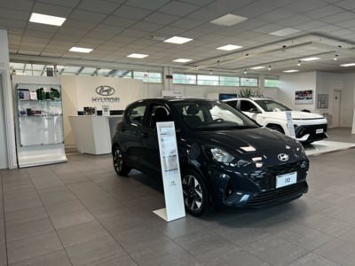 Hyundai i20 blu scuro e Hyundai KONA bianca dentro allo showroom