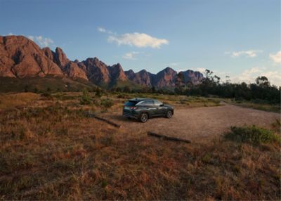 The Hyundai TUCSON Plug-in Hybrid parked with mountains in the background.