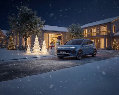 Hyundai BAYON garé dans une allée enneigée devant une maison illuminée pour noël