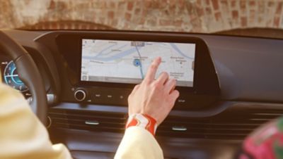 Woman sits in car using the navigation system.