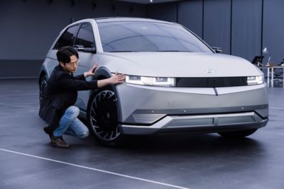 A Hyundai employee taking a close look at the full-electric Hyundai IONIQ 5.