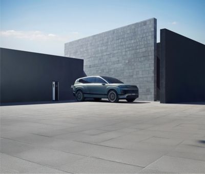 SUV elettrico Hyundai IONIQ 9 in carica davanti a una casa.