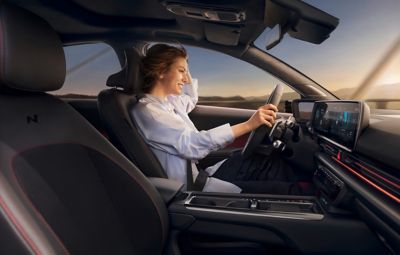 Hyundai’nin sürücü koltuğunda oturan bir kadın. 