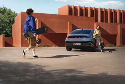 Şehirde bir cadde üzerinde, yüksek binaların önünde park halindeki Hyundai IONIQ 6 elektrikli sedanın yandan görünümü.