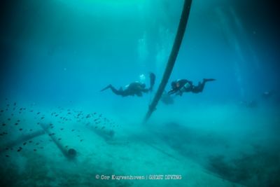 Deux plongeurs de Ghost Diving récupérant des déchets marins sous l’eau