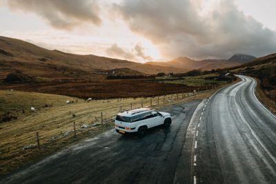 The Hyundai Santa Fe parked outside a modern building with sun and shadows.