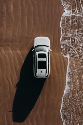 The Hyundai Santa Fe driving a curvy road with mountains in the background. 