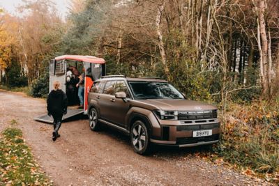 Hyundai SANTA FE towing a horsebox on the road.