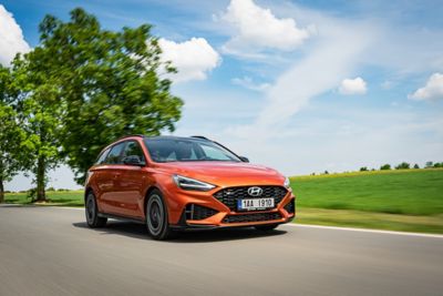 Hyundai i30 jedoucí na silnici v přírodě.