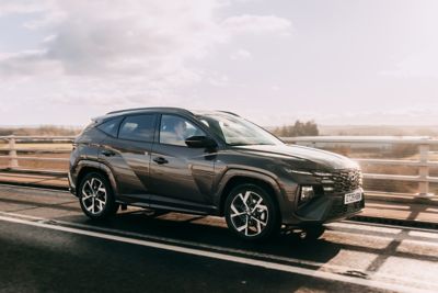 Hyundai TUCSON Hybrid driving on top a bridge.