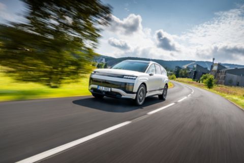 Model Hyundai IONIQ 9 projíždějící po okresní silnici