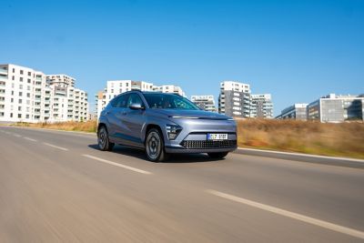 Hyundai KONA Electric jedoucí po okresní silnici.