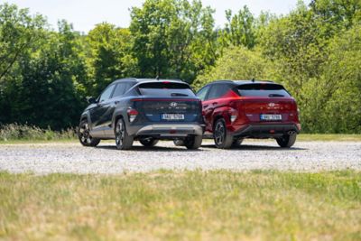 The all-new Hyundai KONA is pictured from the side driving down a city street.