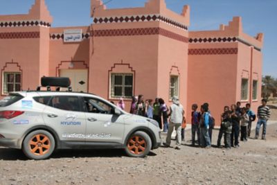 Coche de Hyundai del desierto de los niños frente a un grupo de personas.