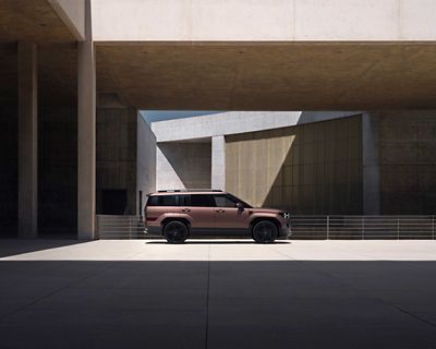 SANTA FE Plug-in Nouvelle Génération stationné devant un immeuble moderne entre ombre et soleil.