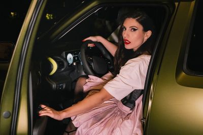 Un uomo controlla il suo smartphone dietro Hyundai i20 gialla parcheggiata in una strada 