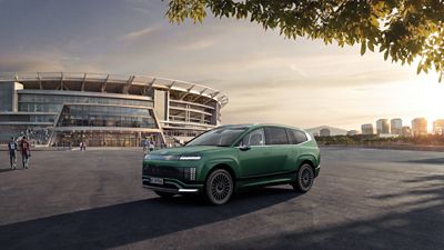  Der Hyundai IONIQ 9 steht vor einem Fußballstadion.
