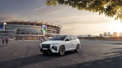 Ein Hyundai TUCSON, schräg von vorne, fährt vor einem Parkhaus in eine Unterführung.