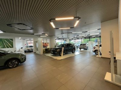 Interno showroom con Gamma Hyundai esposta, al centro una KONA Nera
