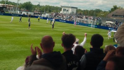   Blick hinter die Zuschauer, die den Fußball verfolgen und jubeln