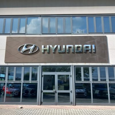 Donna carica un modello Hyundai aiutata da un'assistente Hyundai