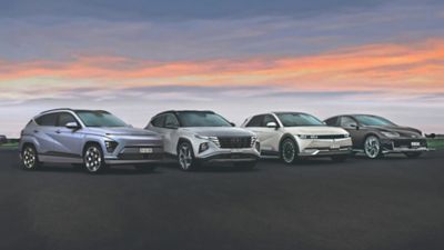 Hyundai Fahrzeuge geparkt vor einem modernen Gebäude mit KONA Elektro und IONIQ 5 N im Vordergrund.