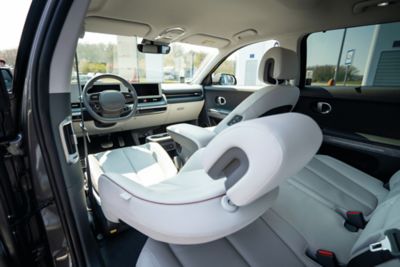 Femme allongée sur le siège passager incliné à bord de son CUV électrique Hyundai IONIQ 5.