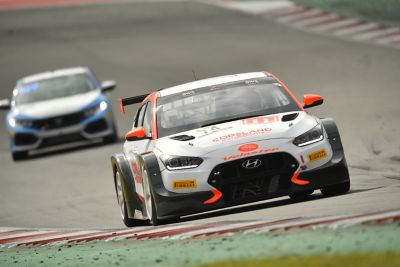  An image of Hyundai Motorsport’s i30 Veloster N TCR in action on a racetrack shown from the front.	