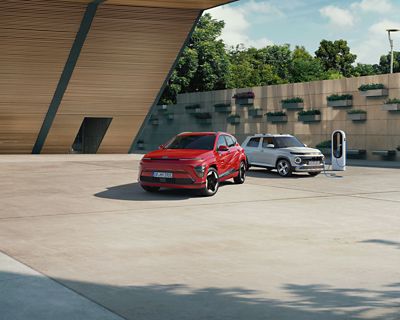 Hyundai INSTER roule sur une route devant un long bâtiment