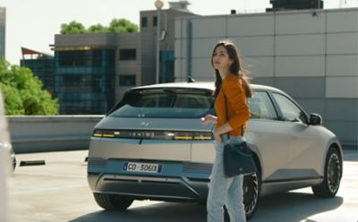Ragazza di fronte alla sua Hyundai IONIQ 5