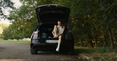 bezkyna sediaca v kufri hyundai ioniq 5 zavazujuca si snurky a pripravujuca sa na beh