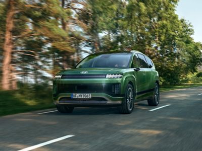 Ein grüner Hyundai IONIQ 9 fährt auf der Landstraße.