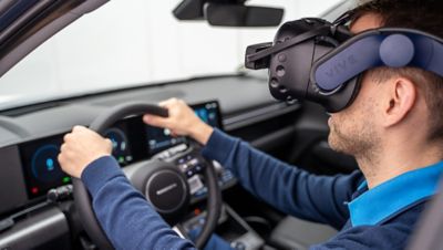 Ein Hyundai Showroom-Presenter führt mit Hilfe einer VR-Brille zahlreiche Assistenzsysteme und individuelle Modellhighlights vor.