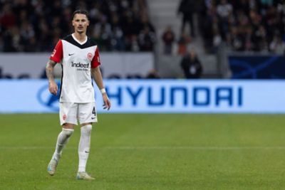 Der Eintracht-Frankfurt-Spieler Robin Koch steht im Eintracht-Trikot auf einem Fußballplatz.