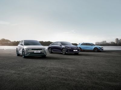 Die Hyundai Modelle IONIQ 6, IONIQ 5 und IONIQ 5 N fahren gestaffelt auf einer breiten Asphaltpiste.
