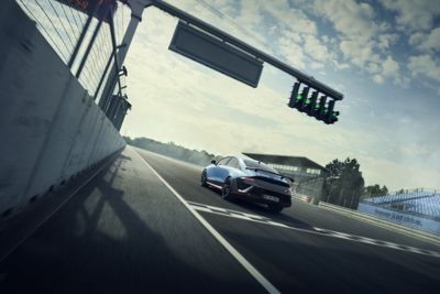 Heckansicht des Hyundai IONIQ 6 N beim Start auf der Rennstrecke während eines Hochgeschwindigkeitsrennens.