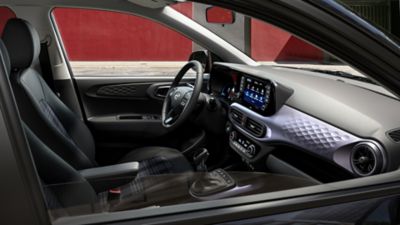 Blick in das Interieur eines Hyundai i10 mit Lenkrad, Displays und Bedienelementen.
