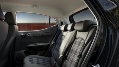 Das hintere Interieur eines Hyundai i10 mit grau gemusterten Sitzen.