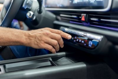 Eine Hand bedient die Klimaanlage eines Hyundai Fahrzeugs.
