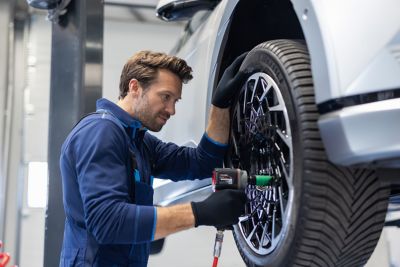 Ein Hyundai Service-Techniker beim Reifenwechsel.
