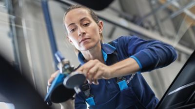 Eine Hyundai Service-Technikerin repariert einen Steinschlag in einer Scheibe.