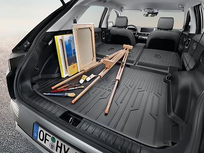 Eine Staffelei, Leinwände und Malutensilien werden auf einer Hyundai Kofferraum-Formschalenmatte transportiert.