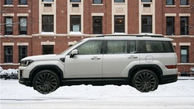 Ein im Schnee parkender Hyundai SANTA FE mit eingeschalteter Standheizung und bereits abtauenden Scheiben.