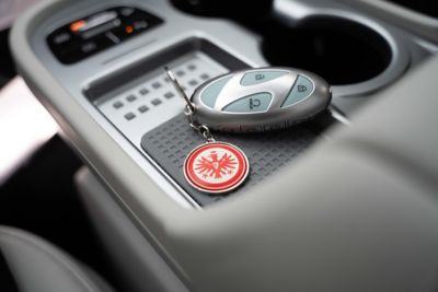 Ein Hyundai Fahrzeugschlüssel mit Eintracht Frankfurt Schlüsselanhänger auf der Mittelkonsole eines Hyundai. 