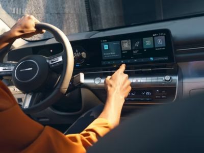 A person using the centre touchscreen inside the Hyundai KONA.
