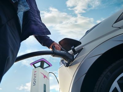 A person charging the Hyundai IONIQ 5 electric midsize CUV from an IONITY charging station.