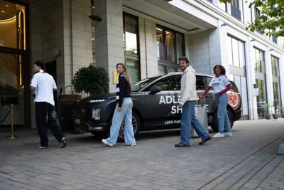 Eintracht Frankfurt Fans vor einem Hyundai IONIQ 9, der vor einem Hotel parkt. 
